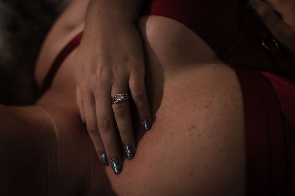 Details of a woman in red lingerie resting her hand with fresh nails done at a nail salons in collierville tn on her chest