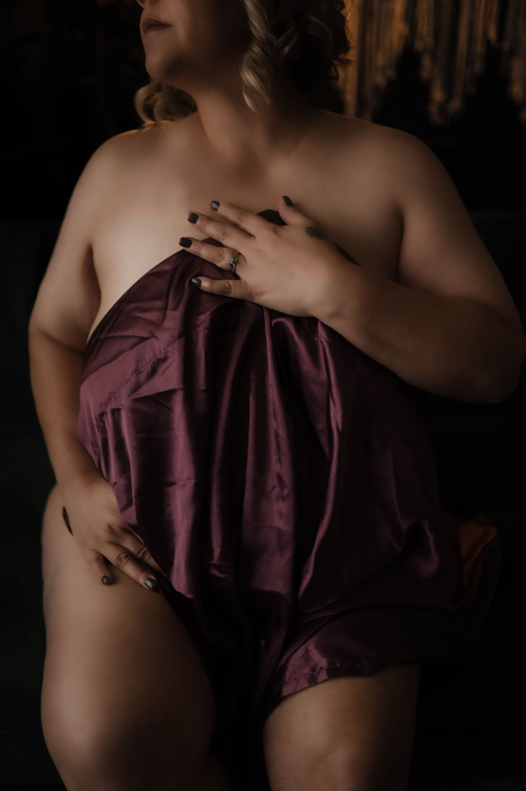 A woman stands in a studio covering with a purple sheet after visiting a nail salon hernando ms