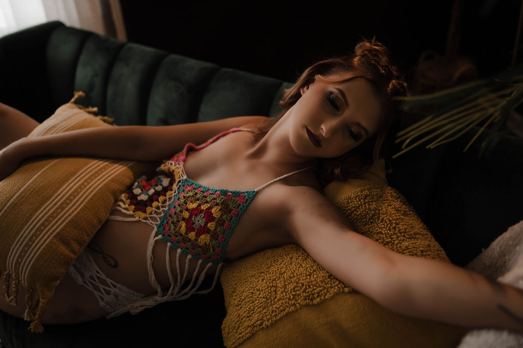 A woman in a knit bra lays across a couch in a studio after some yoga hernando ms